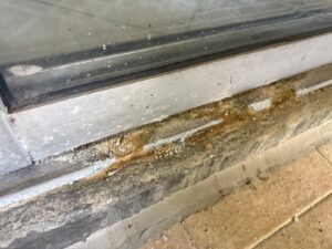 “sliding door track filled with dirt and debris before cleaning