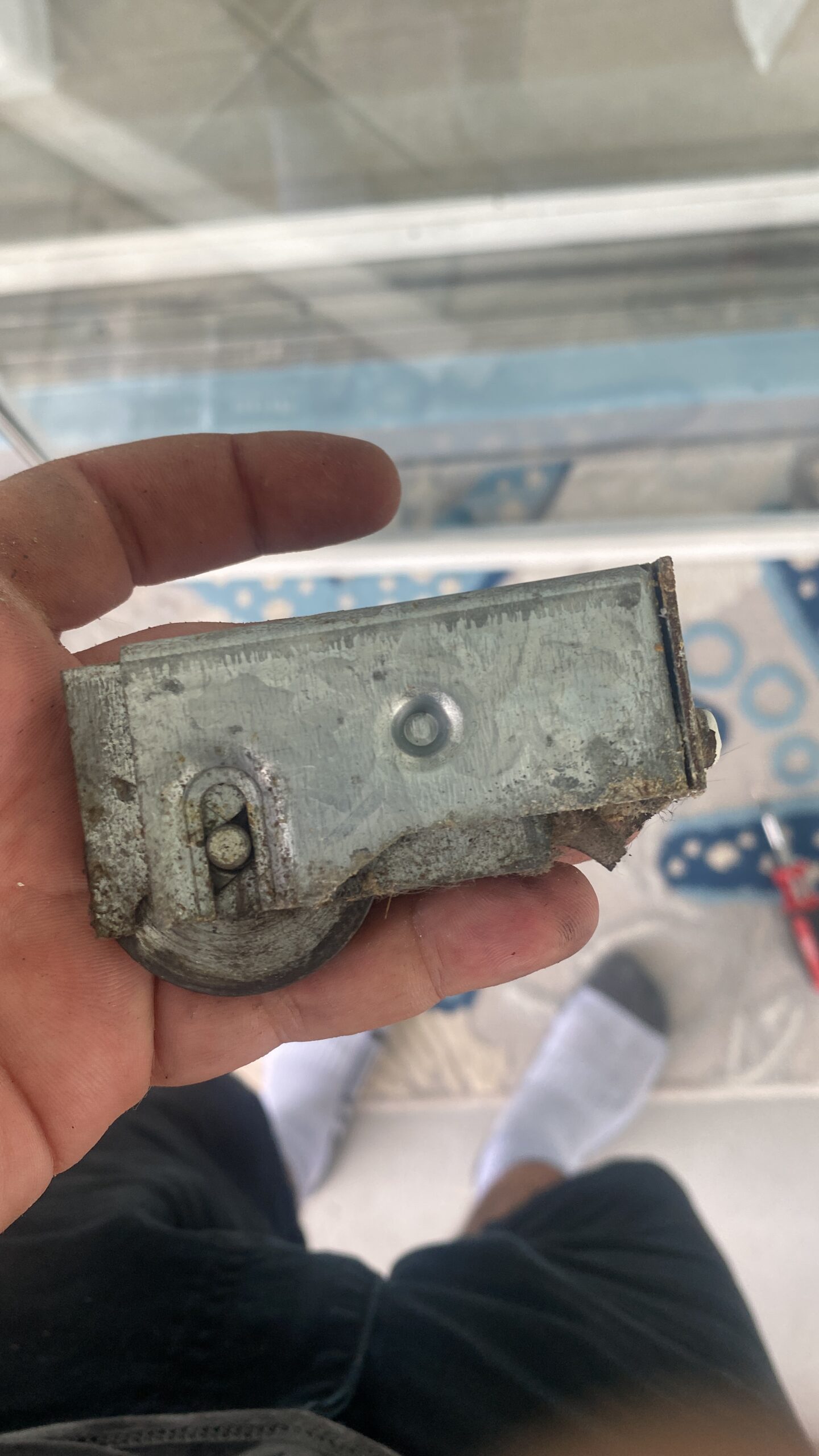 Corroded sliding door roller housing from Florida salt air