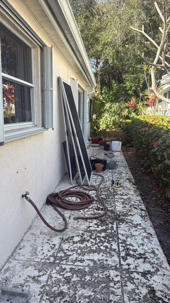 Sliding glass door panels removed and staged outside Florida home during repair